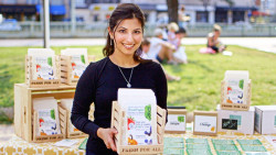 Kavita Shukla smiles while holding a basket of vegetable seed packs